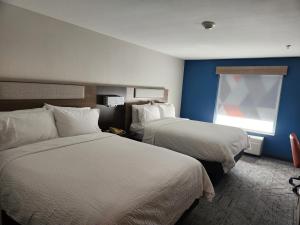 Perry佩里智选假日酒店的酒店客房设有两张床和窗户。