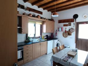 VrysoulesTraditional Villa Sofia的厨房配有木制橱柜、桌子和水槽。