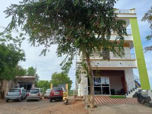 蓬蒂切里Guru Residency Pondicherry的前面有汽车停放的建筑