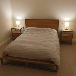 LostockChurstonBnB, private flat within family home, Bolton的一间卧室配有一张带2个床头柜的大床