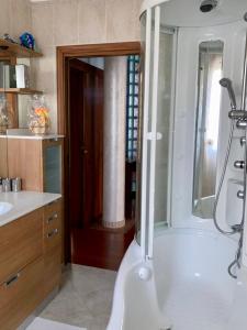 索托马里纳Chilli House的带淋浴和白色浴缸的浴室