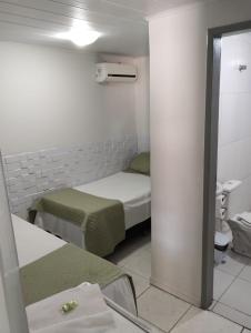 阿拉卡茹Pousada Aracaju的小房间设有两张床和镜子