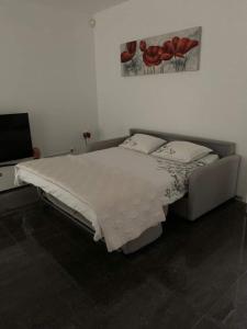 戈尔多拉Moderno bilocale vista lago Maggiore的卧室配有一张床,墙上挂有绘画作品