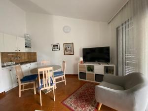 普纳特Apartments Natasa的客厅配有桌椅和电视。