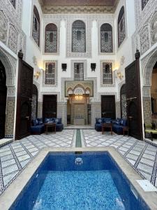 非斯Le Grand Alcazar - Riad的大型客房,位于一座大楼内,设有游泳池