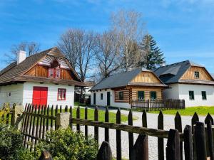 赫林斯科Chalupy Betlém Hlinsko的两栋房屋设有红色门和木栅栏