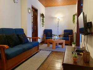 瓦莱迪坎布拉Rosinha Country House的客厅配有沙发和两把椅子