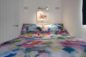 威廉堡The Carriage的卧室内一张带五颜六色棉被的床