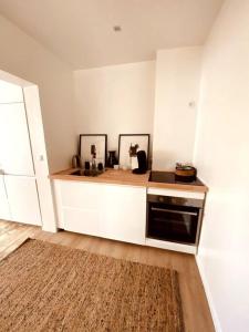 RixensartAppartement 1 chambre - LAKE SIDE HOUSE的厨房配有白色橱柜和黑色洗碗机