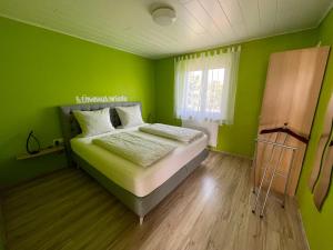 鲁斯特杜斯特旅馆的绿色卧室设有床和窗户