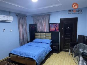 伊巴丹Dex & Flex Apartments的一间卧室配有一张床、一把椅子和风扇