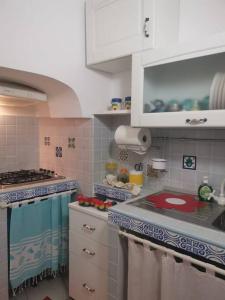 加利波利Casa Centro storico Gallipoli的厨房配有白色橱柜和红色台面