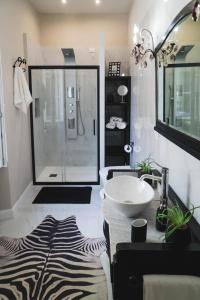 卢卡BELVEDERE Luxury Apartment, view on the Lucca Walls的一间带水槽和玻璃淋浴的浴室