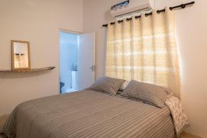 巴拉瓜里La Maria Casa Campo的卧室配有一张带两个枕头的床和窗户