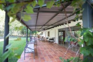 巴拉瓜里La Maria Casa Campo的房屋内带长凳和桌子的庭院