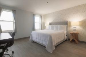 韦斯特伯鲁韦斯特伯勒旅舍的卧室配有一张白色大床和一张书桌