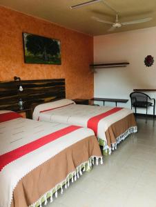 瓦哈卡市El Rincón de Doña Bety的橙色墙壁客房的两张床