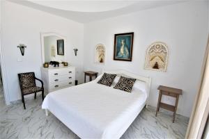 杰尔吉斯VILLA KIKA ZARZIS, LOCATION CHAMBRES D'HÔTES en TUNISIE的白色卧室配有床和椅子