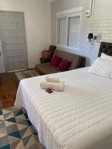 本图贡萨尔维斯Casa no Vale dos Vinhedos em Bento Gonçalves的一间卧室配有一张大床和两条毛巾