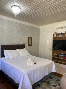 本图贡萨尔维斯Casa no Vale dos Vinhedos em Bento Gonçalves的一间卧室配有一张床,上面有两条毛巾