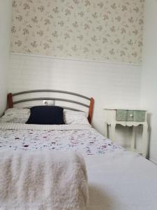 Mareny BarraquetasLa Caseta de Jose的一间卧室配有一张带花卉壁纸的床