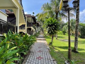 Kampong Sum Sum101 Resort & Spa, Janda Baik的棕榈树屋前的走道