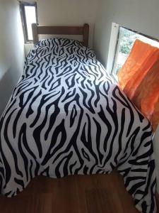 波哥大La casa de chocolate 1的一张带黑白斑马毯子的床