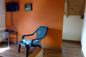 波哥大La casa de chocolate 1的绿色椅子,坐在一个橙色墙壁的房间