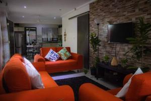 南迪Yaubula Accommodation的客厅配有橙色家具和平面电视。