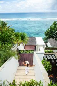 努沙杜瓦Cliff front luxury Olala Nusadua Beach的站在楼梯上看海洋的女人