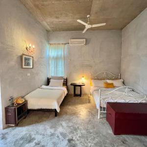 XikouMIRAMONTI House 賣房間更賣生活的一间卧室配有两张床、一张桌子和吊扇。