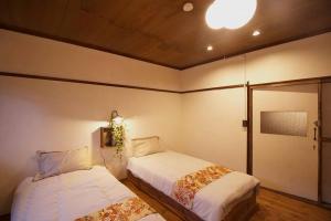 长野1日1組様限定　「ホシナサトマチ 」的一间卧室设有两张床,天花板上拥有灯光