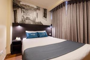 利马Hotel María Luisa的一间卧室配有一张带蓝色枕头的大床