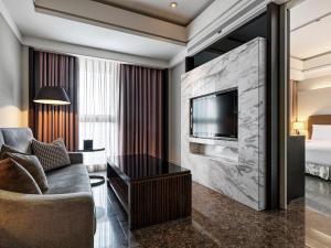 台北六福居的酒店客房设有沙发、电视和床。