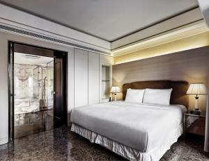 台北六福居的一间卧室配有一张带两盏灯的大型白色床。