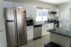 菲利普斯堡Modern 3BR Home with Own Private Pool的厨房配有不锈钢冰箱和白色橱柜