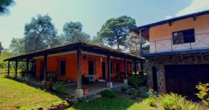 Cerro de OroAmankaya Atitlan的橙色的房子,在庭院里设有一个大庭院