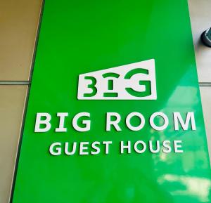 大阪BIG ROOM GUEST HOUSE的大房间宾馆的绿色标志
