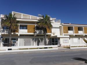 法鲁阿罗马尔酒店的街道前方有棕榈树的建筑