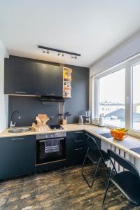 拉克韦雷Apartments24 Laada 4的厨房配有黑色橱柜和带水槽的台面