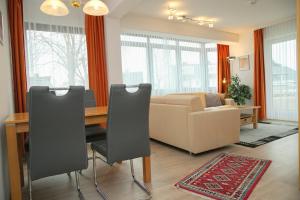 格洛米茨Haus Belvedere App 001 Stellpl 32 inkl WLAN的客厅配有桌子和沙发