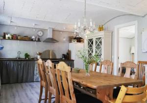 莱斯Landlig idyl på Dommergården Bed and Coffee的厨房以及带木桌和椅子的用餐室。