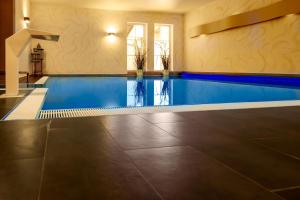库洛特拉森STEIGER Hotel Rathener Hof的一座房子内的游泳池,铺有瓷砖地板