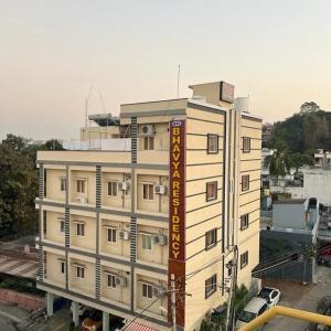 巴德拉恰拉姆SRI BHAVYARESIDENCY的一座白色的大建筑,上面有标志
