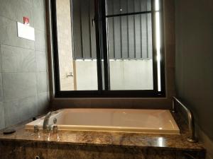 太平觅玥精品时尚旅馆 - 全馆独立空调的带浴缸的浴室和窗户