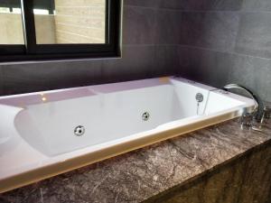 太平觅玥精品时尚旅馆 - 全馆独立空调的浴室设有白色浴缸及镜子