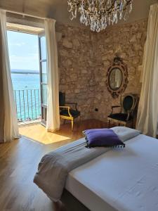 锡拉库扎Dimora Aretusa Luxury的一间卧室设有一张大床和一个大窗户