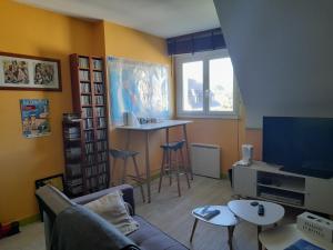 TrégourezKermarco的带沙发、电视和桌子的客厅