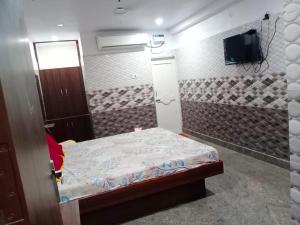 ArakkonamSri Mahalakshmi Deluxe Lodging Arakonam的小房间设有床铺和电视