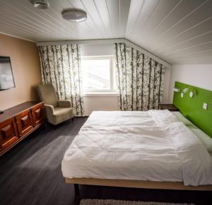 ArtjärviBed and Breakfast Artjärvi的卧室配有床、椅子和窗户。